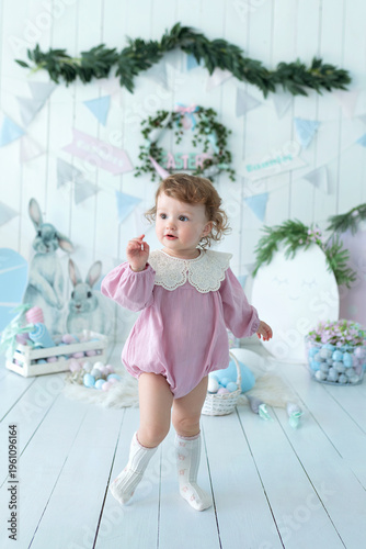 Wallpaper Mural Adorable little toddler girl in a pink dress near basket with Easter eggs. Cute child surrounded by bunny decorations, soft toys, spring festive decor. Easter celebration concept, springtime Torontodigital.ca