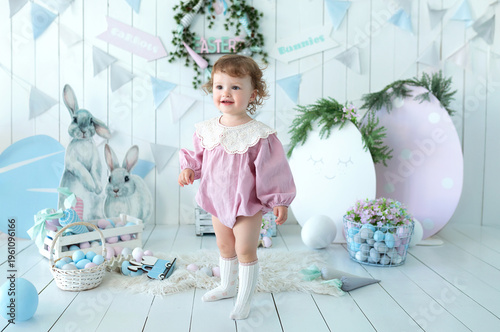 Wallpaper Mural Adorable little toddler girl in a pink dress near box with Easter pastel eggs. Cute child surrounded by bunny decorations, soft toys, spring festive decor. Easter celebration concept, springtime Torontodigital.ca
