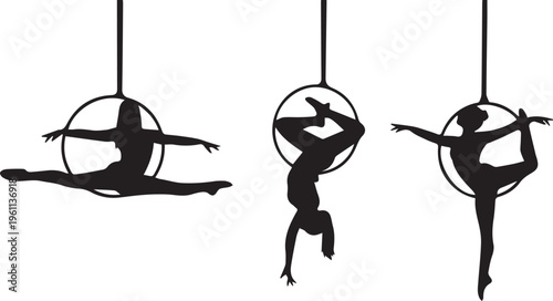 Silhouette of aerialists performing on aerial hoops