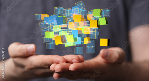 Creative visual of hand holding and interacting with abstract colorful cubes. Representing technology, connections, and