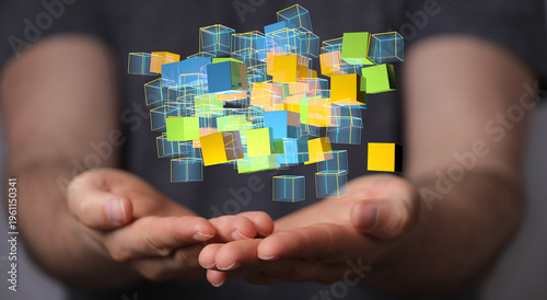 Abstract image of hands supporting a cluster of colorful, interconnected digital cubes, symbolizing data and innovation.