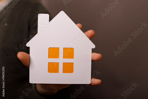 Hand holding paper house, r...