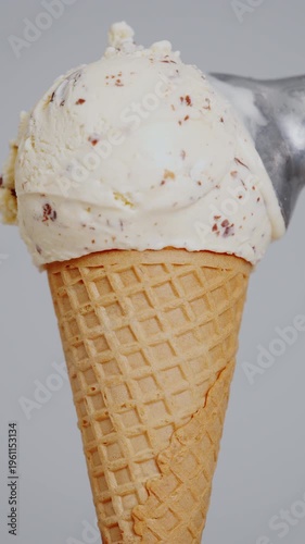 4K Vertical Cookies and cream ice cream scoop in waffle cone isolated on clean background, Sweet dessert with crunchy cookie pieces, ideal for food summer refreshment and commercial product concepts.