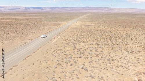 Aerial of car driving through arid desert landscape