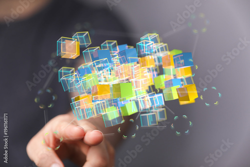 Abstract image showing a hand interacting with a network of colorful 3D cubes representing data processing, technology,