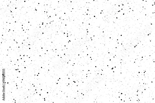 Rough black dots irregularly splattered across a plain white plane providing a gritty feel