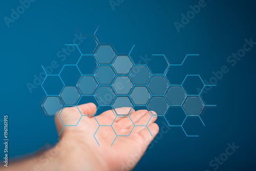Abstract image of a hand interacting with a digital hexagon structure, representing technology, networking, and data.