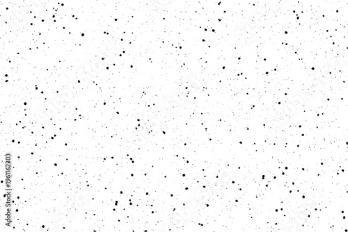 Scattered black particles create a distressed overlay effect on a bright white surface