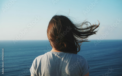 Woman Looking at Ocean Horizon with Wind Blown Hair, Freedom and Travel Concept