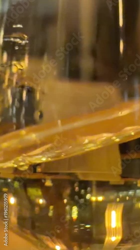 white wine in a glass in a girl's hand. Bride in boho style dress holding a glass of wine while sitting on a chair, close-up of hands. Woman relaxing with a glass of wine. Slow motion.