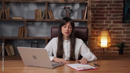 Business woman explains graph trends with confidence during a presentation to her team.