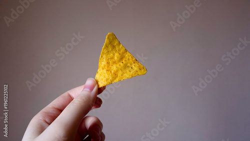 Hand Holding a Single Tortilla Chip, Nachos Mexican Snack Food