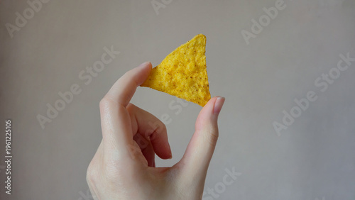Hand Holding a Single Tortilla Chip, Nachos Mexican Snack Food