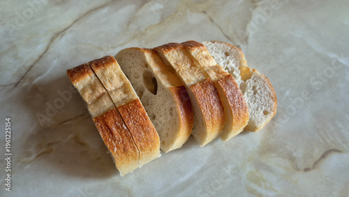 Freshly Sliced Crusty Baguette, White Bread on a Marble Surface, Healthy Food Concept