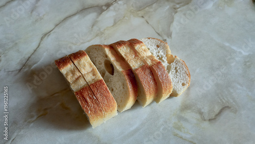 Freshly Sliced Crusty Baguette, White Bread on a Marble Surface, Healthy Food Concept