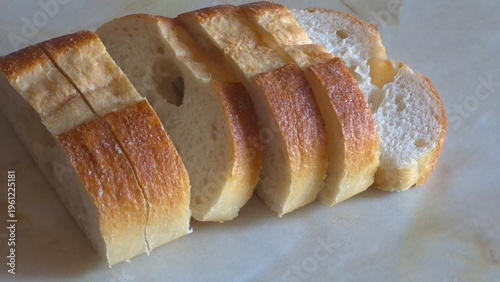 Freshly Sliced Crusty Baguette, White Bread on a Marble Surface, Healthy Food Concept