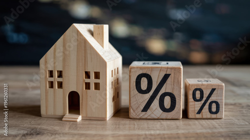 A wooden house model with percentage blocks on a table representing interest rates or financial growth