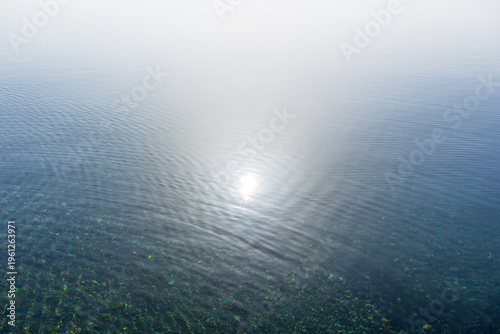 Die Sonne spiegelt sich auf einer ruhigen Wasseroberfläche