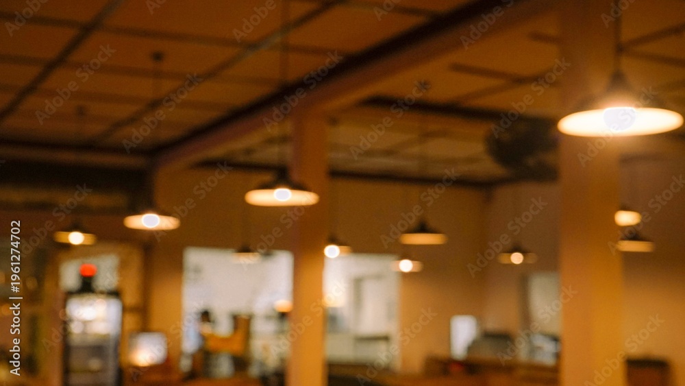 Fototapeta premium Warm blurred interior of a cafe with hanging pendant lights
