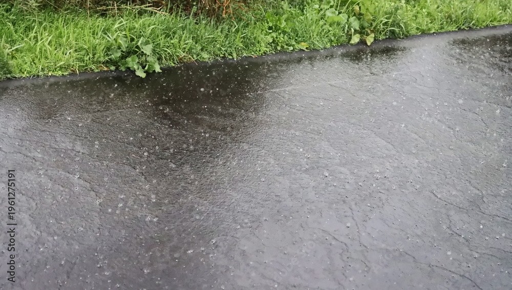 Fototapeta premium Spring rain falls on asphalt background