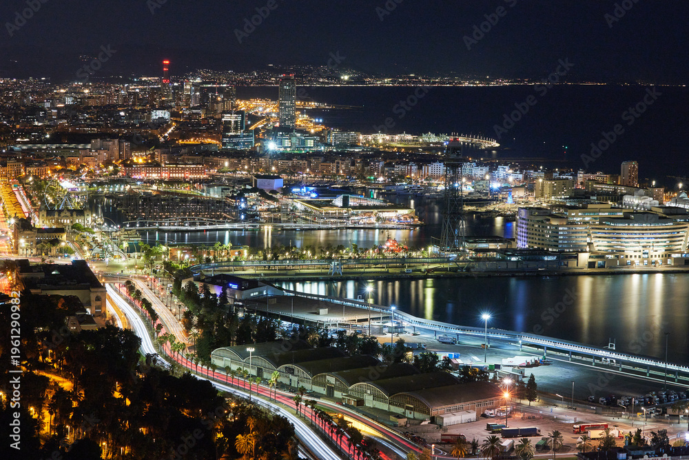 Fototapeta premium la ciudad de Barcelona de noche desde lo alto de la montaña en el mediterráneo