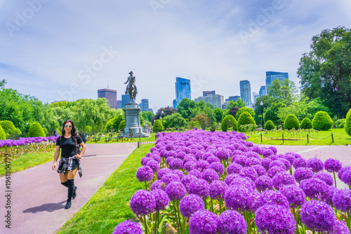 Woman strolls through vibrant purple flowerbeds