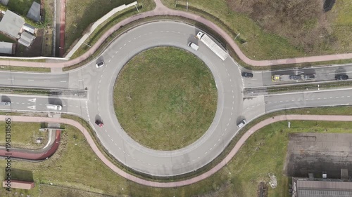 Genk, Belgium. Top-down drone hoovering over busy roundabout with flowing traffic and transport vehicles