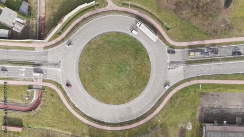 Genk, Belgium. Top-down drone hoovering over busy roundabout with flowing traffic and transport vehicles
