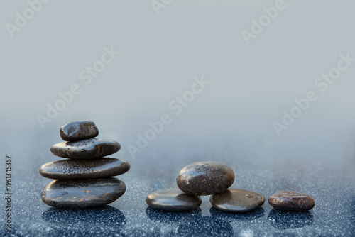 Black spa stones on the gray table background.