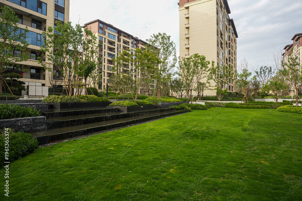 Fototapeta premium Modern residential park with green lawn and cascading water feature - Community peace concept
