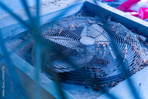 Dusty Air Conditioning Unit with Fan and Leaves in Background