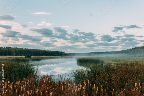 Calm lake with reflection of sky and clouds at sunset