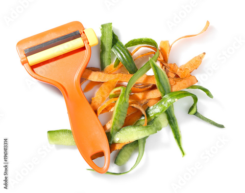Fotografie Pile of organic waste and peeler isolated on white, top view