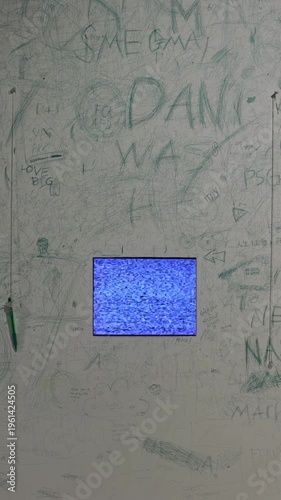Static shot of built-in screen with blue flickering signal on painted wall. Dramatic, eerie mood, vertical 4K background.