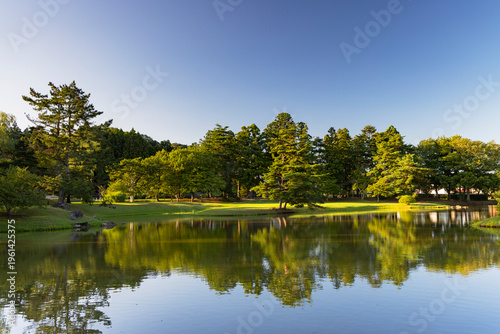Pond at Kanjizaio-in Ato temple surrounded by trees and reflecting clear sky in Hiraizumi, Iwate, Japan