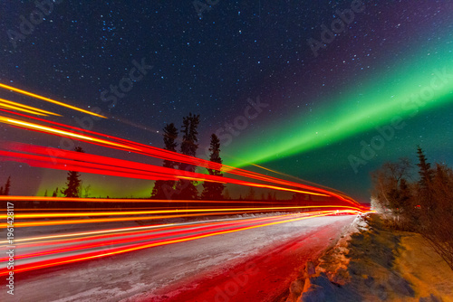 Long exposure of Jeep lights with Aurora Borealis above Great Slave Lake in Northwest Territories Canada