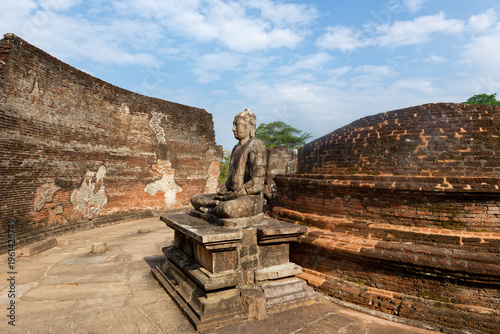 Vatadage circular temple in Polonnaruwa shows ancient architecture and a seated Buddha statue from 12th century Sri Lanka