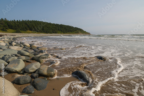 Waves crash on the rocks at the beach near Lawrencetown Provincial Park in Nova Scotia, Canada during late afternoon