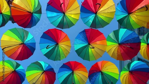 Colorful umbrella canopy viewed from below forming circular geometric composition over street in Karakoy, Istanbul - vibrant urban art