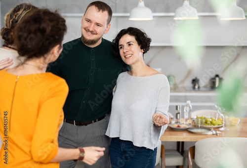 Married couple sees off guests after house party, says goodbye to friends. Party visitors leave hospitable house, take depart event