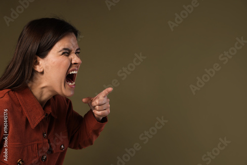 Cuadro en lienzo Resentful woman screaming and pointing at something on dark green background