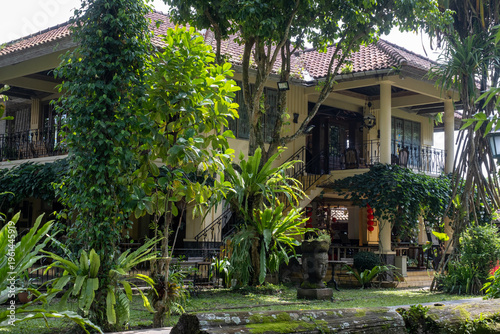 A beautiful villa is nestled amidst dense tropical vegetation, radiating an aura of peacefulness and splendor. The scenery presents an inviting outdoor ambiance, surrounded by vivid greenery.