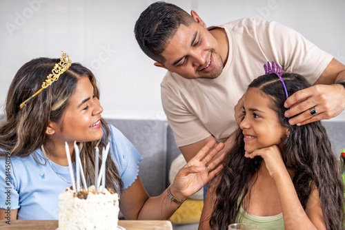 Fotografie Loving father crowning daughter at home birthday celebration