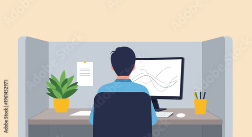 Man working diligently on his computer at an office desk in a bright studio, seen from behind.