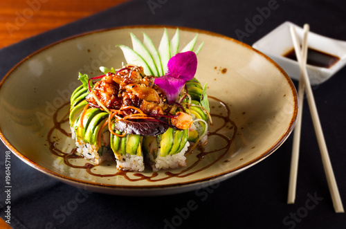 Volcano sushi roll topped with avocado with dipping sauce at a Thai restaurant
