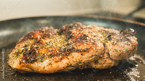 Fotografía Boneless lamb frying in a hot pan with herbs and seasoning, developing a golden crust