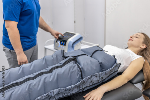 Canvastavla Doctor controls pressotherapy near woman on treatment table