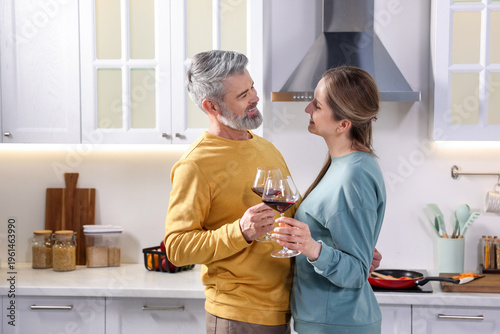 Photos Lovely couple with glasses of wine in kitchen