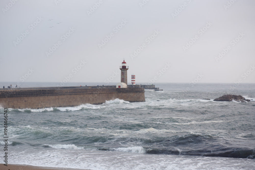 Obraz premium Lighthouse on the Atlantic Ocean with waves in Porto, Portugal