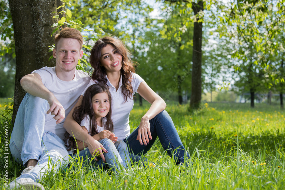 Fototapeta premium A very happy family on the green grass
